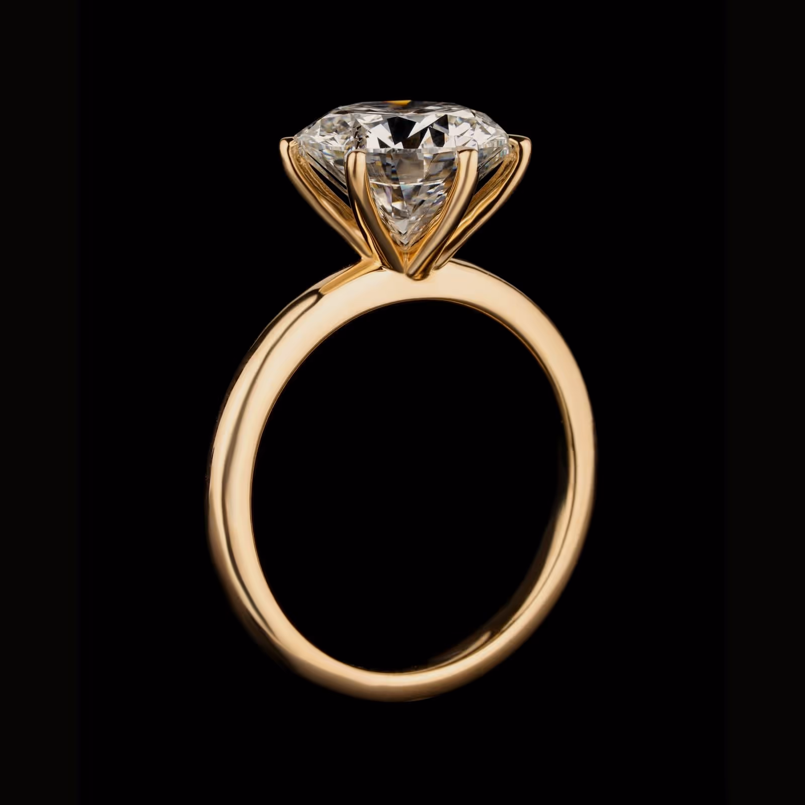 A gold solitaire, low angle, one brilliant held high