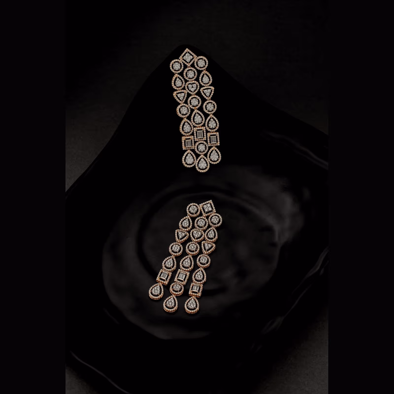 A pair of long drop earrings on black silk