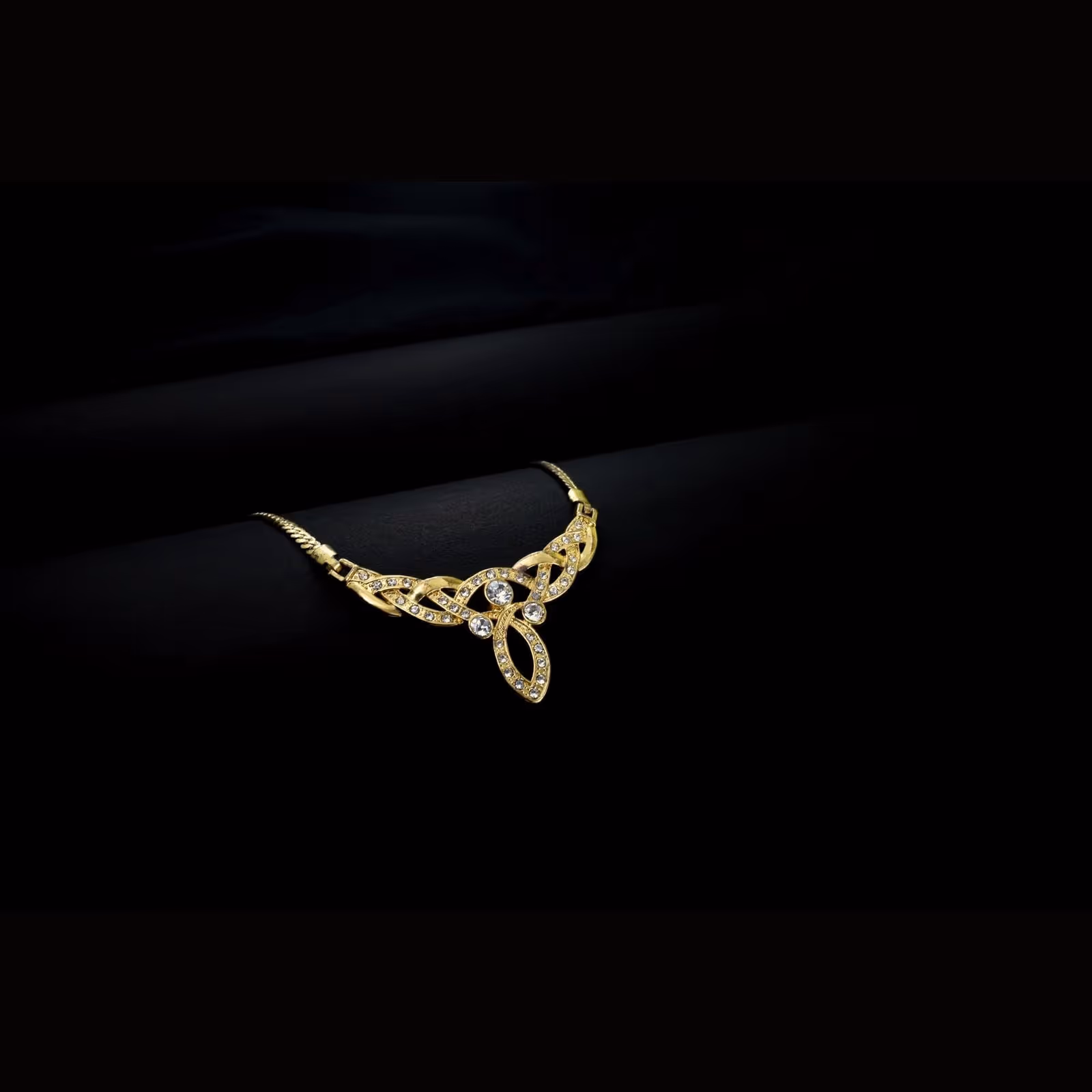 A fine gold necklace laid on dark cloth
